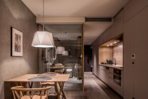 套房内部，设有餐桌、厨房和玻璃浴室