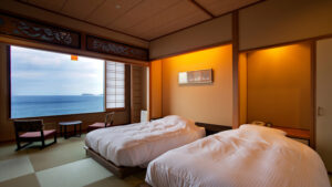 Lits jumeaux dans une chambre en tatami avec vue sur l’océan