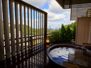 Open-air bath on balcony with trees and sky
