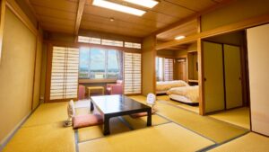 Tatami-Zimmer mit niedrigem Tisch, Bodenstühlen und Einzelbetten