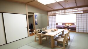 テーブルと椅子、ツインベッドを備えた畳の客室
