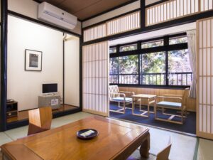 Tatamizimmer mit Tisch, Stühlen und Sitzplätzen am Fenster