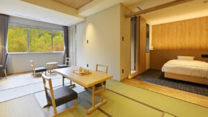 Tatamizimmer mit niedrigem Tisch und angrenzendem Bettbereich