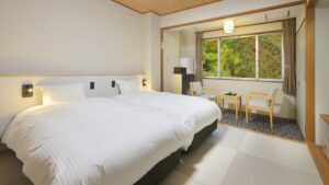 Zwei Einzelbetten neben einem Sitzbereich am Fenster