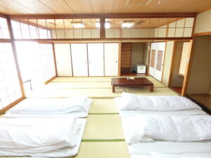 Tatamizimmer mit ausgelegten Futons und niedrigem Tisch
