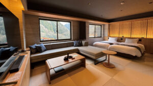 Chambre avec lits jumeaux et coin salon avec canapé