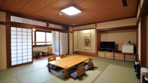 Chambre tatami avec table basse, chaises de sol et télévision