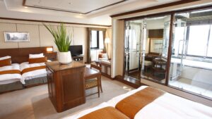 Gästezimmer mit zwei Einzelbetten und verglastem Badbereich