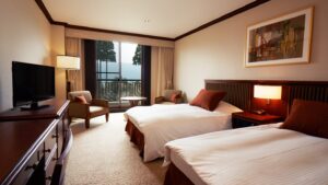 Zwei Einzelbetten in einem Gästezimmer mit Stühlen am Fenster