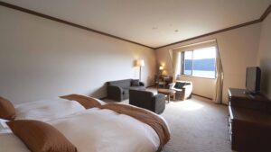 Zwei Einzelbetten im Gästezimmer mit Stühlen am Fenster