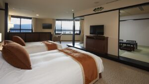 Zwei Einzelbetten im Gästezimmer mit Tatami-Sitzbereich