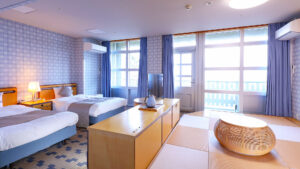 Zwei Einzelbetten in einem Gästezimmer mit Tatami-Sitzbereich