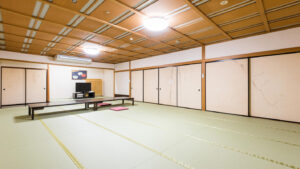 Amplia habitación de tatami con mesas bajas y cojines en el suelo