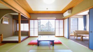 Habitación de tatami con mesa baja, cojines y zona de estar