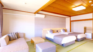 Dos camas individuales y sofá en habitación de tatami