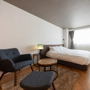 Bett neben Sessel und kleinem Tisch im Gästezimmer