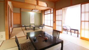 Chambre en tatami avec tables basses et chaises près de la fenêtre