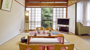 Camera in tatami con tavolino basso, cuscini e televisore