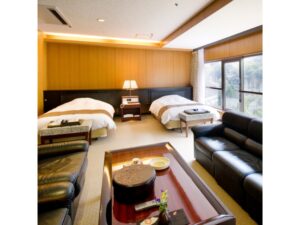 Letti singoli e area salotto con divano in una camera