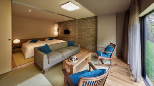 Schlafzimmer mit Sofaecke und großem Fenster