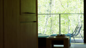 Tagesbett und Stuhl am Balkonfenster mit Waldblick