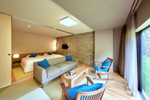 Sofa und Stühle im Gästezimmer neben den Betten