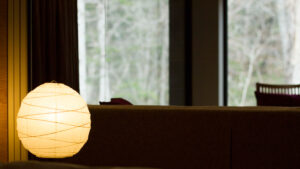 Sofa am Fenster mit leuchtender Papierlampe