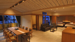 Habitación con mesa de comedor, sofá y dos camas individuales