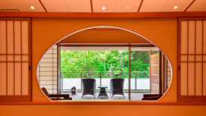 Dos sillas junto a una ventana con vistas a un jardín verde