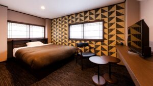 Chambre avec lit double, chaises et mur à motifs