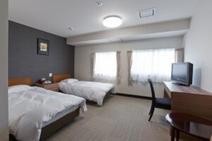 デスクとテレビのある客室のツインベッド