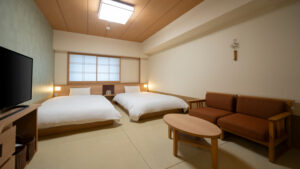 두 개의 낮은 침대와 소파가 있는 다다미방