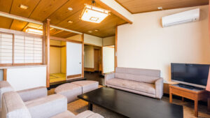 Chambre de style tatami avec canapés, table et télévision