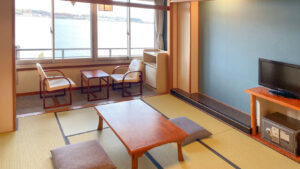 Chambre en tatami avec table basse, chaises et vue par la fenêtre