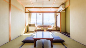 Chambre en tatami avec table basse, coussins de sol et fenêtre