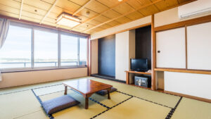 Chambre en tatami avec table basse, coussins de sol et fenêtre
