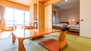 低いテーブルと隣接するベッドのある畳の部屋