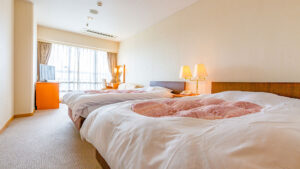 明るい客室にある3台のベッド