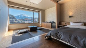 Camera da letto con letto, area salotto in tatami e vista sulle montagne