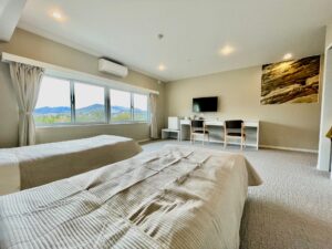 Twin beds in a guest room with desk and window