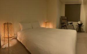 Bed with floor lamps and chair in guest room