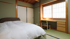 책상과 쇼지 창문이 있는 다다미방의 침대