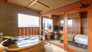 침대와 창문이 있는 객실 옆의 전용 원형 욕조