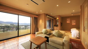 Coin salon avec canapé près des baies vitrées du balcon dans la chambre
