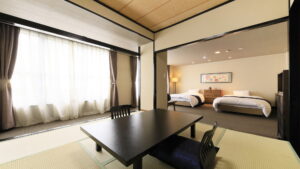 Coin salon en tatami à côté d’une chambre avec lits jumeaux