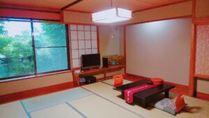 Tatamizimmer mit niedrigem Tisch, Sitzkissen und Fenster