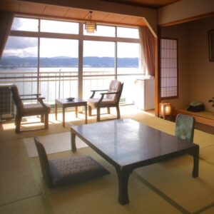 Chambre en tatami avec table basse, chaises et vue sur le lac