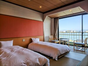 Lits jumeaux dans une chambre en tatami face à la fenêtre du balcon