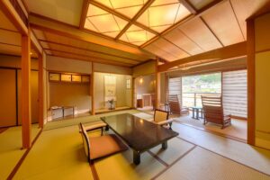 窓際に低いテーブルと椅子がある畳の客室