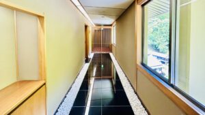 Corridoio interno con finestre e passaggio in piastrelle nere